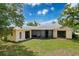 Home backyard featuring well-maintained lawn and mature trees at 7337 Cone Shell Dr, Spring Hill, FL 34607