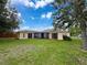 Home backyard featuring well-maintained lawn and a screened lanai at 7337 Cone Shell Dr, Spring Hill, FL 34607