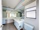Bathroom with double sinks, tile floors, and natural light from a window at 7337 Cone Shell Dr, Spring Hill, FL 34607