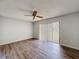 Well-lit bedroom showcasing wood-look floors, ceiling fan, and sliding glass door to outdoor space at 7337 Cone Shell Dr, Spring Hill, FL 34607