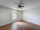 Spacious bedroom featuring wood-look floors, ceiling fan, and arched window providing natural light at 7337 Cone Shell Dr, Spring Hill, FL 34607