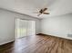 Bright bedroom with wood-look floors, ceiling fan, and sliding glass door leading to the backyard at 7337 Cone Shell Dr, Spring Hill, FL 34607