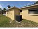 Exterior shot of the home featuring new HVAC unit and yellow painted stucco at 7337 Cone Shell Dr, Spring Hill, FL 34607