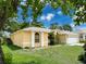 Well-maintained home exterior featuring a lush green lawn, manicured plants and bright yellow paint at 7337 Cone Shell Dr, Spring Hill, FL 34607