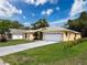 Exterior view of a charming single-story home with a manicured lawn and two car garage at 7337 Cone Shell Dr, Spring Hill, FL 34607