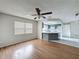 Living room with wood floors, ceiling fan, and view to the kitchen at 7337 Cone Shell Dr, Spring Hill, FL 34607