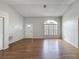 Bright living room with hardwood floors, neutral paint, and arched window, ready for personalization at 7337 Cone Shell Dr, Spring Hill, FL 34607