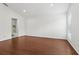 Primary bedroom featuring an ensuite bathroom, window with shutters, and hardwood floors at 2731 Penzance St, Palm Harbor, FL 34684