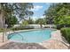 Community pool with surrounding foliage and brick pavers at 2731 Penzance St, Palm Harbor, FL 34684
