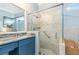 Bathroom featuring glass shower, neutral tile, and blue vanity at 13064 N Marsh Dr, Port Charlotte, FL 33953