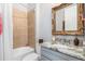 A well-lit bathroom featuring decorative vanity mirror, tiled walls, and tiled shower at 13064 N Marsh Dr, Port Charlotte, FL 33953