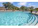 Inviting community pool with comfortable lounge seating under colorful umbrellas at 13064 N Marsh Dr, Port Charlotte, FL 33953