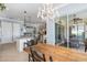 Bright dining room with access to the lanai, featuring a rustic table and chairs under a chandelier at 13064 N Marsh Dr, Port Charlotte, FL 33953