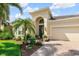 Charming single Gathering home featuring lush landscaping, a beautiful arched entryway, and attached two-car garage at 13064 N Marsh Dr, Port Charlotte, FL 33953