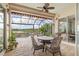 A covered lanai with outdoor dining area, ceiling fan, brick pavers and view of the pool and pond at 13064 N Marsh Dr, Port Charlotte, FL 33953