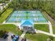 Aerial view of well-maintained pickleball courts with shaded seating area, perfect for an active lifestyle at 13064 N Marsh Dr, Port Charlotte, FL 33953