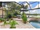 Enclosed pool area with a water feature, lounge area, tropical plants and a beautiful lake view at 13064 N Marsh Dr, Port Charlotte, FL 33953