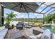 A screened in lanai featuring a pool with a waterfall and a seating area overlooking a tranquil lake at 13064 N Marsh Dr, Port Charlotte, FL 33953