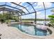 A screened-in pool with a waterfall feature, lush landscaping, and an inflatable swan create a relaxing outdoor oasis at 13064 N Marsh Dr, Port Charlotte, FL 33953