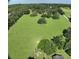 Aerial view of a sprawling property featuring a large green field and mature trees at 17380 Sweetwater Rd, Dade City, FL 33523