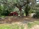Property with barn, secondary shed, fire pit and bridge over waterway on a tree-lined lot at 17380 Sweetwater Rd, Dade City, FL 33523