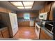Kitchen with white appliances, wood floors, and wood cabinets at 17380 Sweetwater Rd, Dade City, FL 33523