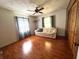 Living room with a light couch, dark curtains, wood floors, and a ceiling fan at 17380 Sweetwater Rd, Dade City, FL 33523