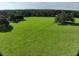 Vast green pasture with mature trees and wooden fencing, perfect for livestock or recreation at 17380 Sweetwater Rd, Dade City, FL 33523