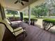 Relaxing covered porch with a swing and cushioned chairs, perfect for outdoor enjoyment at 17380 Sweetwater Rd, Dade City, FL 33523