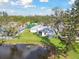 This backyard shows a serene pond view with lush grass, mature trees, and a glimpse of the home's exterior at 3118 34Th Avenue E Dr, Bradenton, FL 34208