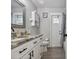 Bathroom featuring a white vanity with marble countertops, modern fixtures, and wood-look tile flooring at 3118 34Th Avenue E Dr, Bradenton, FL 34208