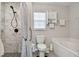 Bright bathroom featuring a bathtub, a walk-in shower, white tiled walls and gray flooring at 3118 34Th Avenue E Dr, Bradenton, FL 34208