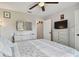 Bedroom with wood-look flooring, ceiling fan, neutral decor, and a TV on the white dresser at 3118 34Th Avenue E Dr, Bradenton, FL 34208