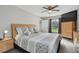 Bright bedroom with neutral tones, a ceiling fan, wood furnishings, and an outside view from the window at 3118 34Th Avenue E Dr, Bradenton, FL 34208