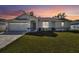Charming single-story home featuring a well-manicured lawn and a two-car garage at sunset at 3118 34Th Avenue E Dr, Bradenton, FL 34208
