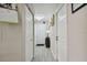 Well-lit hallway featuring gray wood floors, white doors, and a decorative light fixture at 3118 34Th Avenue E Dr, Bradenton, FL 34208