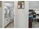Hallway view into bathroom with white cabinets, and a glimpse into the living room with TV at 3118 34Th Avenue E Dr, Bradenton, FL 34208