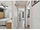 Hallway featuring wood-look tile floors leads to the bedroom with ceiling fan and a bathroom with white cabinets at 3118 34Th Avenue E Dr, Bradenton, FL 34208