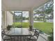 Screened-in porch with table, chairs, and views of the landscaped yard and pond at 3118 34Th Avenue E Dr, Bradenton, FL 34208
