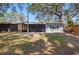 The house has a screened-in porch, mature trees, and a lush yard at 7214 Oakwood Dr, New Port Richey, FL 34652