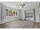 Cozy bedroom featuring wood floors, a ceiling fan, and sliding doors to a screened-in porch at 7214 Oakwood Dr, New Port Richey, FL 34652