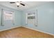 Cozy bedroom featuring wood floors, dual windows providing ample natural light, and a ceiling fan at 7214 Oakwood Dr, New Port Richey, FL 34652