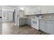 Updated kitchen featuring white cabinets, granite countertops, stainless steel appliances and wood floors at 7214 Oakwood Dr, New Port Richey, FL 34652