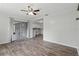 Open living area with wood floors, a ceiling fan, and access to the kitchen and screened-in porch at 7214 Oakwood Dr, New Port Richey, FL 34652
