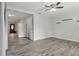 Bright, open living room with wood-look tile, ceiling fan, and freshly painted walls at 7214 Oakwood Dr, New Port Richey, FL 34652