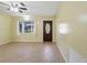 Sunlit living room featuring wood-look flooring, a front entry door, and a window with natural light at 7214 Oakwood Dr, New Port Richey, FL 34652