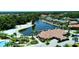 Aerial view of a lakefront neighborhood featuring mature trees, waterfront homes, beach, and lush landscaping at 18018 Malakai Isle Dr, Tampa, FL 33647