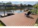 Waterfront backyard featuring a wood deck with relaxing chairs on a canal with boat access at 18018 Malakai Isle Dr, Tampa, FL 33647