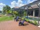 Landscaped backyard with a wood deck, patio, pool, and relaxing chairs offers a great space for relaxation at 18018 Malakai Isle Dr, Tampa, FL 33647
