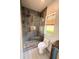 Modern bathroom showcasing a walk-in shower with tiled walls, decorative tile flooring, and a bright window at 18018 Malakai Isle Dr, Tampa, FL 33647